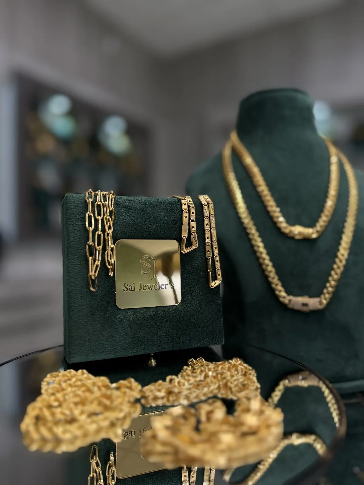 Gold chains and necklaces on emerald velvet at Sai Jewelers