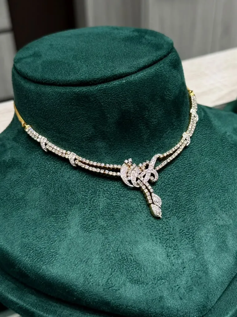 Diamond floral necklace with a double row of stones displayed on an emerald velvet bust