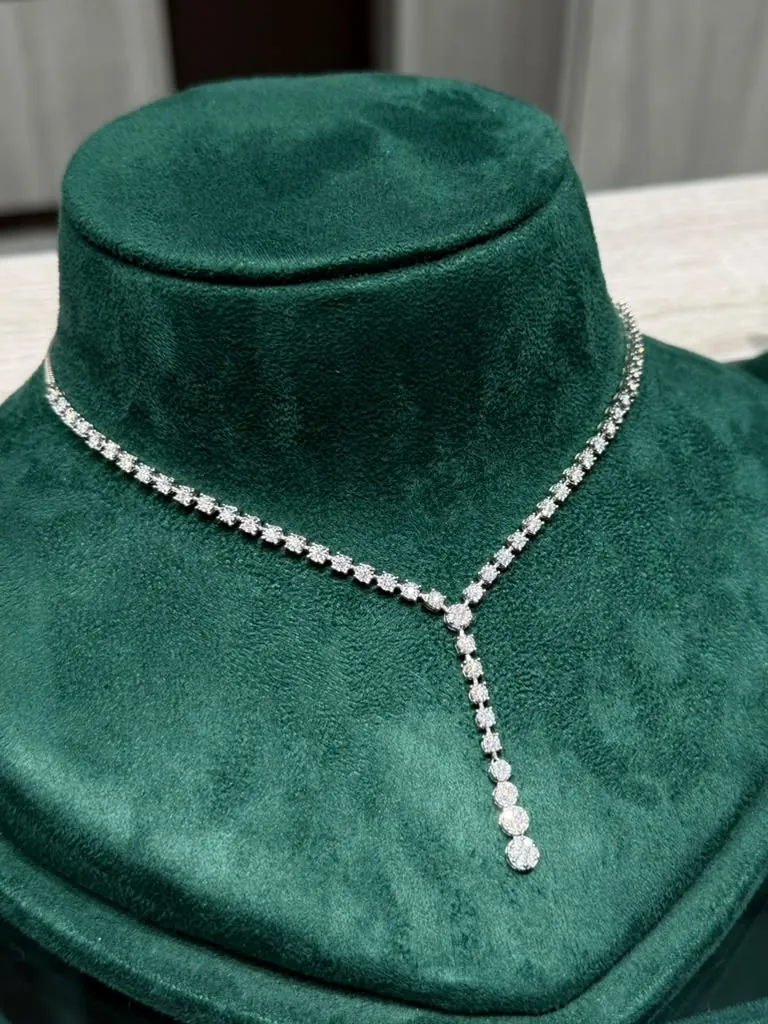 Diamond lariat necklace with a graduated drop on an emerald velvet bust